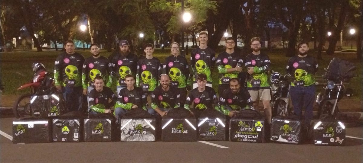 Equipe de entregadores da UFO uniformizada, com os baús de entrega enfileirados